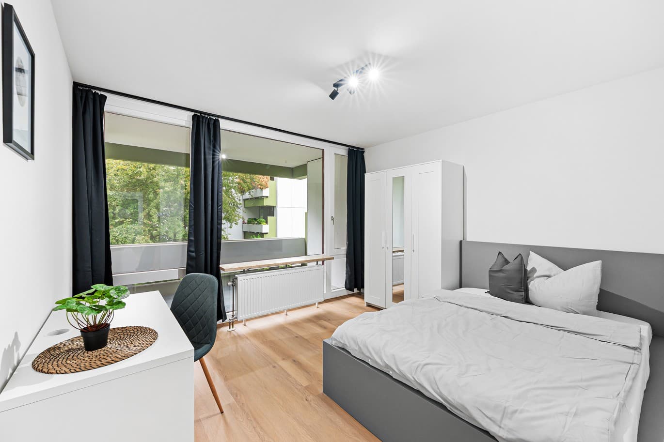 Zimmer mit Balkonzugang und Arbeitsplatz nach der Sanierung