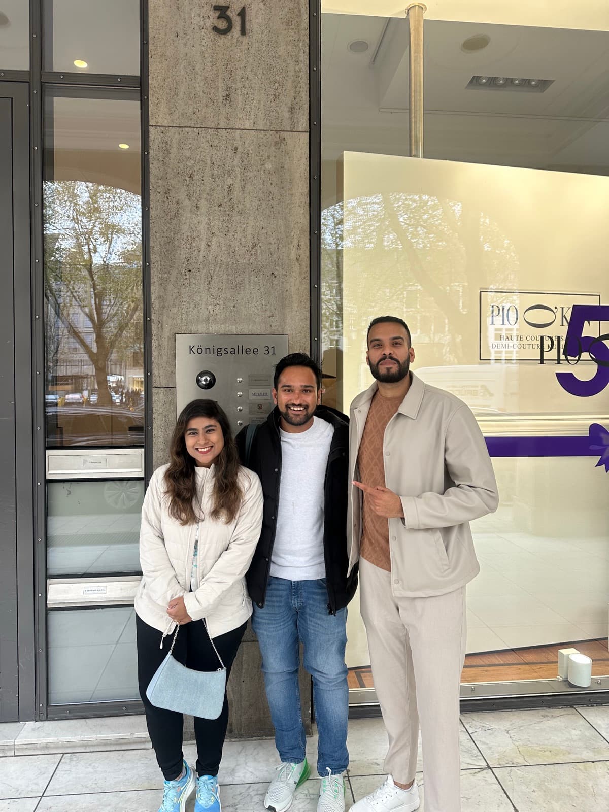 Kundin und Kunde mit einem Berater von Sandeep Real Estate vor einem Bürogebäude in Düsseldorf