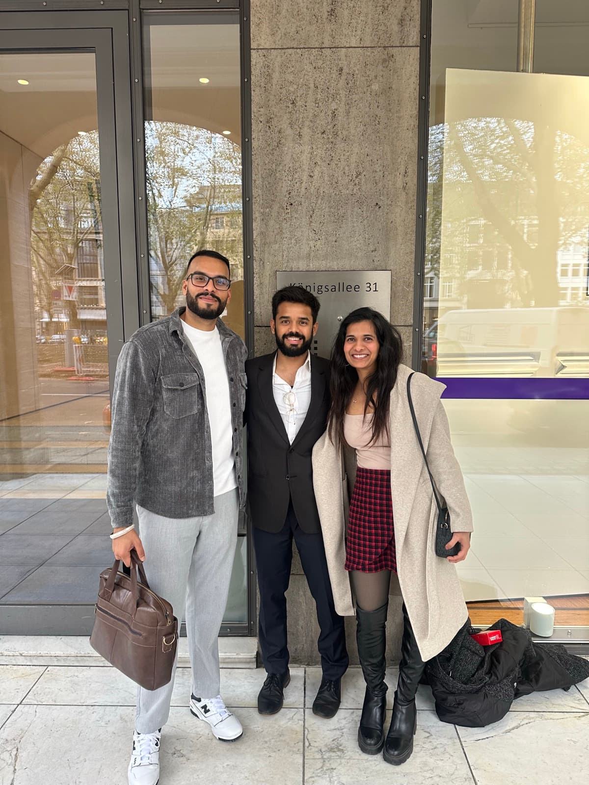 Kundenpaar mit einem Berater von Sandeep Real Estate vor einem Bürogebäude in Düsseldorf